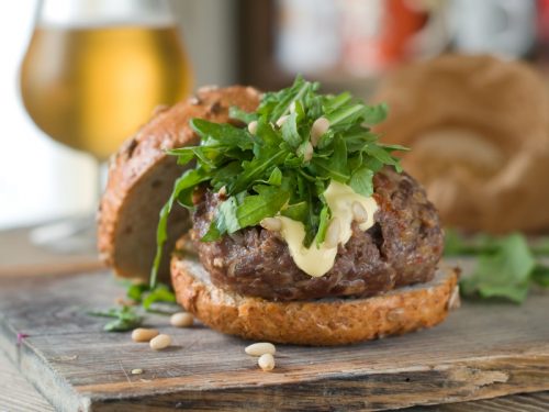 Hamburger with burger, arugula and pine nuts, selective focus